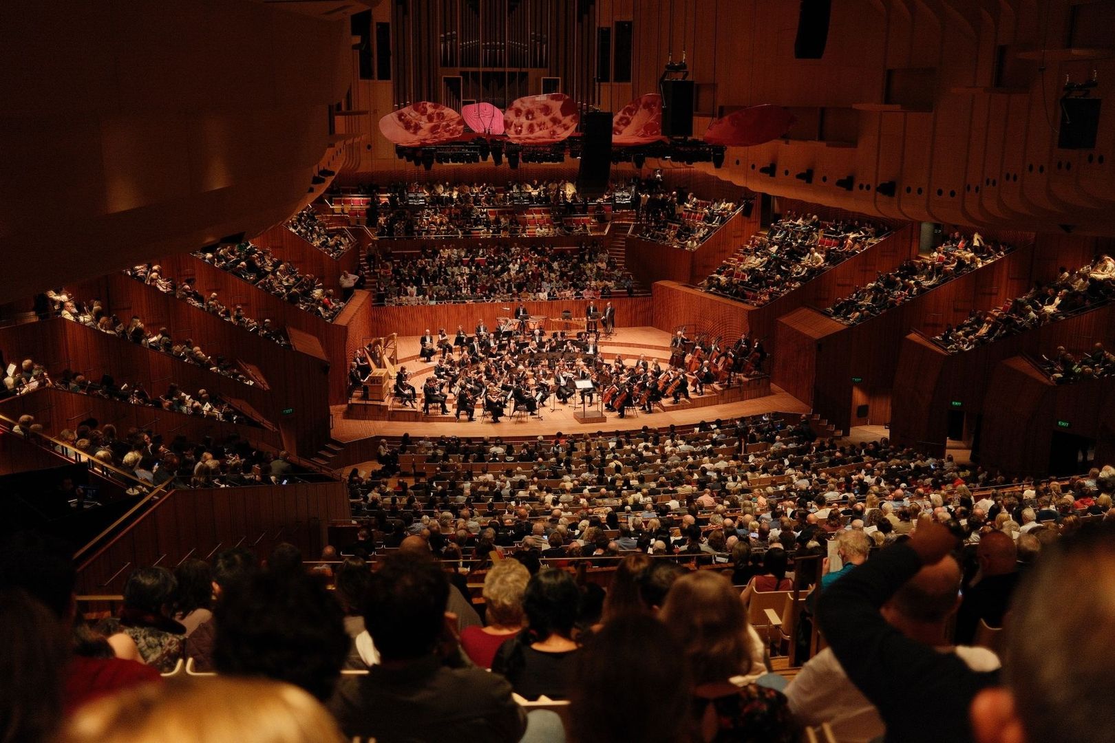 Orchester und dicht besetztes Publikum in einem modernen Konzertsaal