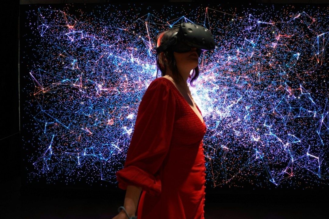 Person mit VR-Brille vor einer leuchtenden digitalen Netzwerkgrafik